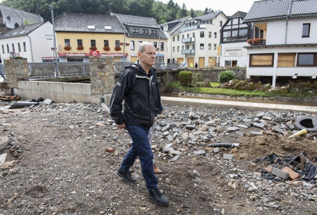 Energisch geht Olaf Scholz nach dem Hochwasser im Sommer eine Uferpromenade in Schleiden entlang. Ebenso energisch geht er politisch mal in die eine Richtung, mal in eine andere.