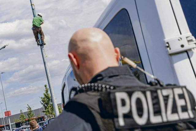 Ein Polizist sperrt am Tesla-Werk den Zugang zur Kletteraktion v...