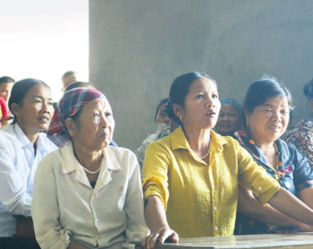 Quach Thi Huong berichtet bei einer Dorfversammlung über Klimawandelfolgen.
