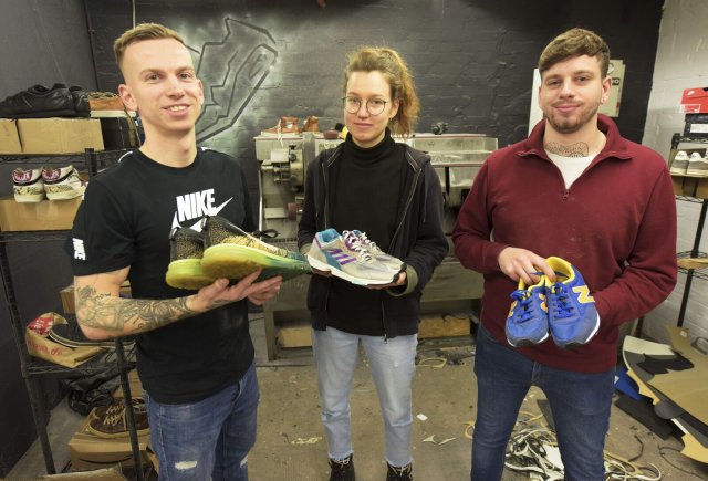 Hagen Matuszak (links) mit zwei weiteren Sneaker-Rettern in ihrer Neuköllner Werkstatt