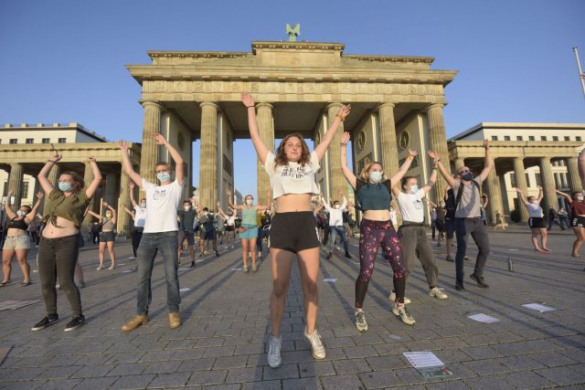 Klima-Aktivistin Michelle Grunwald (Mitte) und ihre Freund*innen machen mit einem Flashmob vor dem Brandenburger Tor auf ihre Forderungen aufmerksam.