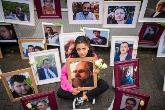 Die syrische Aktivistin Wafa Mustafa sitzt aus Protest vor dem Oberlandesgericht in Koblenz zwischen Bildern von Opfern des syrischen Regimes und hält ein Bild ihres Vaters. AFP/Thomas Lohnes