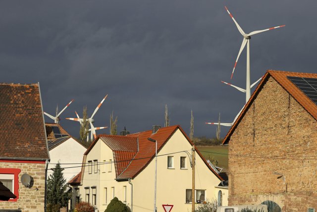 Windräder drehen sich hinter den Häusern des kleinen Ortes Heldrungen in Thüringen. Foto: dpa/Jan Woitas
