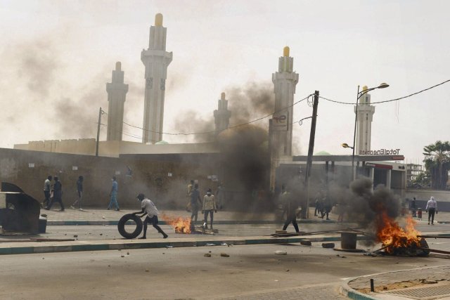 Bei Zusammenstößen mit der Polizei verbrennen oppositionelle Demonstranten Reifen in Senegals Hauptstadt Dakar.