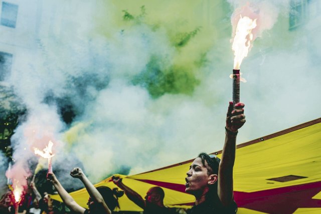 Anhänger der Unabhängigkeitsbewegung zünden ihre bengalischen Lichter an, während sie unter einer riesigen Estelada-Flagge vor dem Fosser de Moreres-Denkmal am katalanischen Nationalfeiertag (11. September) in Barcelona demonstrieren.