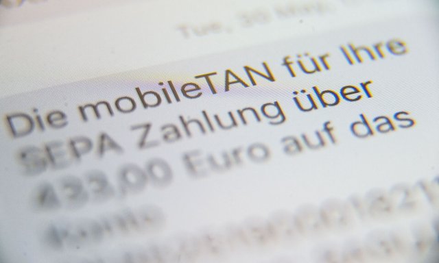 Eine SMS, in der eine sogenannte mobileTAN" zur Verifikation von Banküberweisungen angezeigt wird, steht auf dem Display eines Handys.
