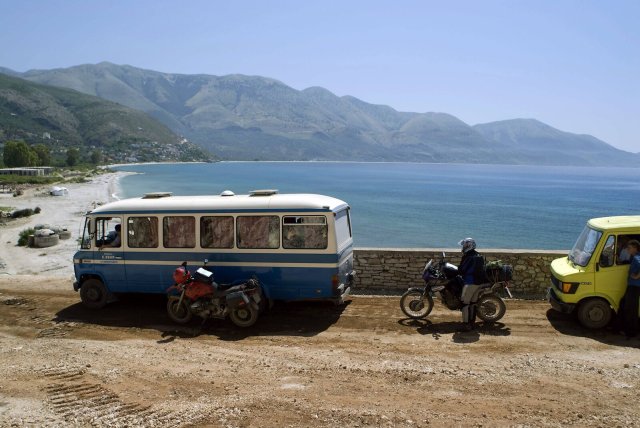 Reisende parken mit ihrem Bus am Strand bei Borsh in Albanien.