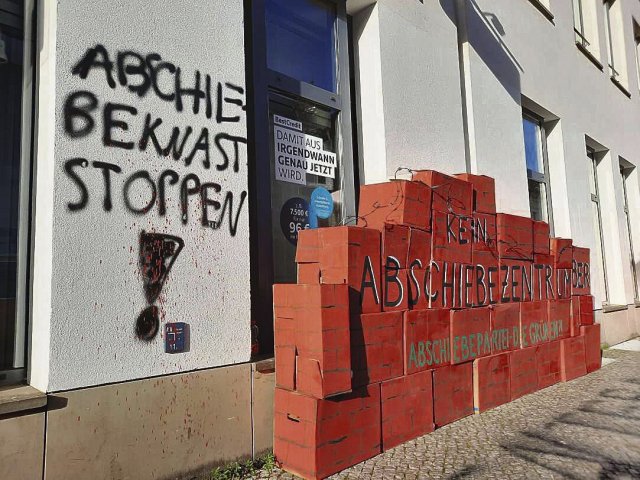 Das Graffiti ist schon ein paar Tage alt, die rote Mauer kam am Dienstag hinzu. Trotz zahlreicher Protestaktionen scheinen die Grünen am Abschiebezentrum festzuhalten.
