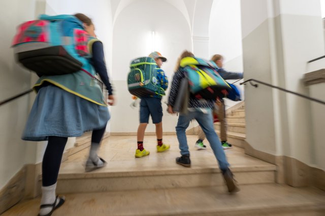 Kinder mit Schulranzen laufen am ersten Schultag in Bayern die Treppe an der Grundschule hoch. Bei Viertklässlern gibt es große Unterschiede beim sprachlichen Ausdrucksvermögen.