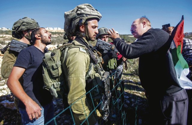 Die neue israelische Regierung hat einen Ausbau der Siedlungen angesagt: Ein Palästinenser streitet mit einem jüdischen Siedler, der die Armee auf seiner Seite weiß.