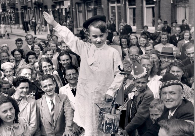 Niederländer feiern die Befreiung ihrer Hauptstadt Amsterdam von der Nazi-Okkupation. Der kleine Junge bietet mit seinem Farbeimer eine Parodie auf den Anstreicher Adolf Hitler.