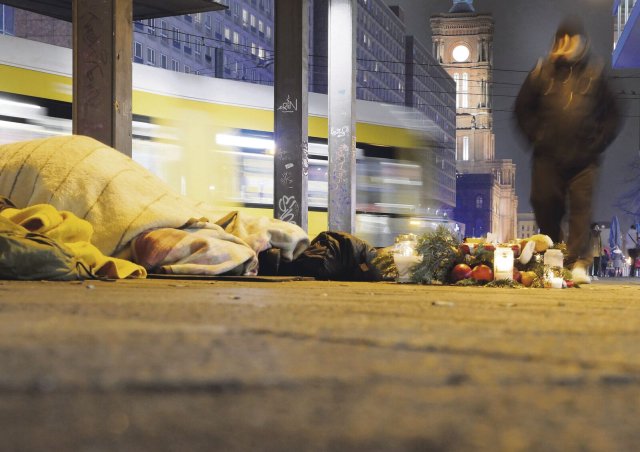 Menschen schlafen unter widrigen Bedingungen unter der S-Bahn-Brücke am Alexanderplatz.