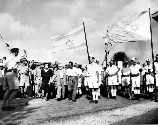 Wie alles anfing: Zusammen mit dem neuen israelischen Militär verabschiedet David Ben Gurion (mit Jackett) die letzten britischen Soldaten in Haifa am 3. Juli 1948.