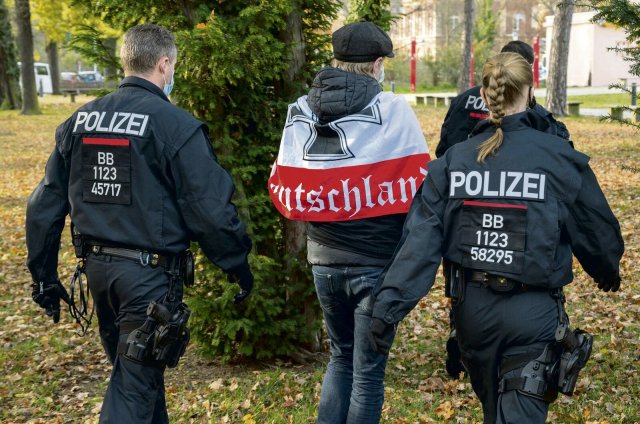Die Polizei begleitet den Träger einer Reichskriegsflagge in Potsdam: Rechtsmotivierte Straftaten stellen in Brandenburg noch immer den größten Anteil.