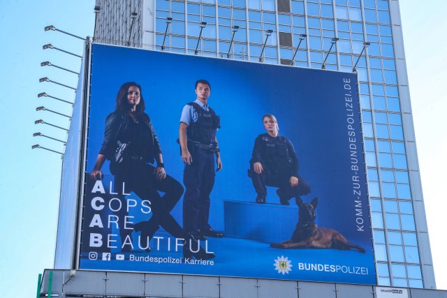 Hinweisgeber aus den eigenen Reihen sollen dieses Selbstbild der Polizei und ihres Hundes zukünftig richtigstellen (Plakat am Alexanderplatz in Berlin im Januar in Berlin).