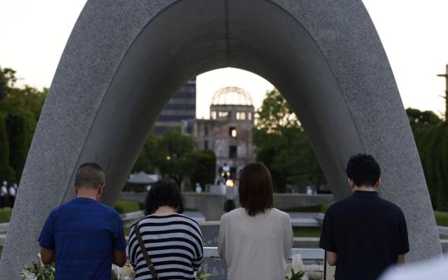 Besucher gedenken vor dem Kenotaph den Opfern des Atombombenabwurfs im Hiroshima Peace Memorial Park.