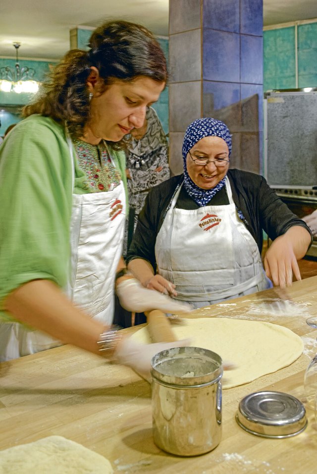 Unter der gestrengen Anleitung von Küchenchefin Hiam (r.) erlernen Besucher die jordanische Kochkunst.