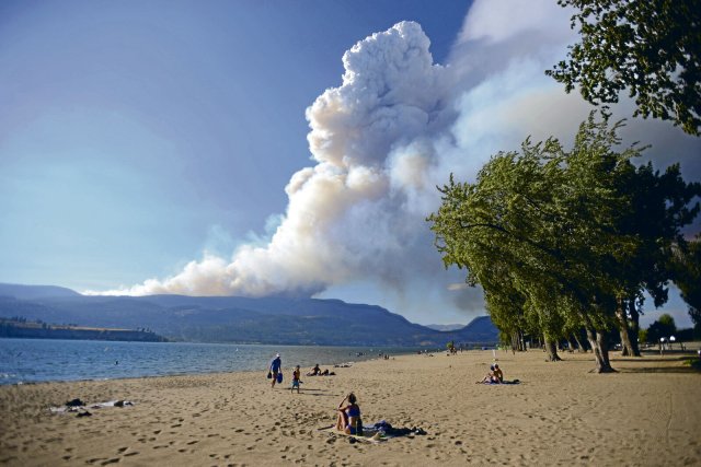 Zeichen der Verwüstung: Rauchsäule über dem Horizont am Strand von Kelowna, British Columbia