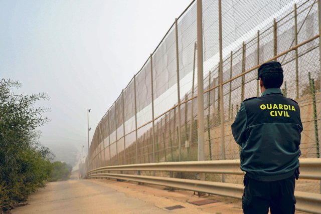 Ein Beamter der Guardia Civil bewacht den Grenzzaun der spanischen Exklave Mellilla. Im Juni 2022 gab es dort bei der Abwehr von Geflüchteten mindestens 23 Tote und viele Verletzte.