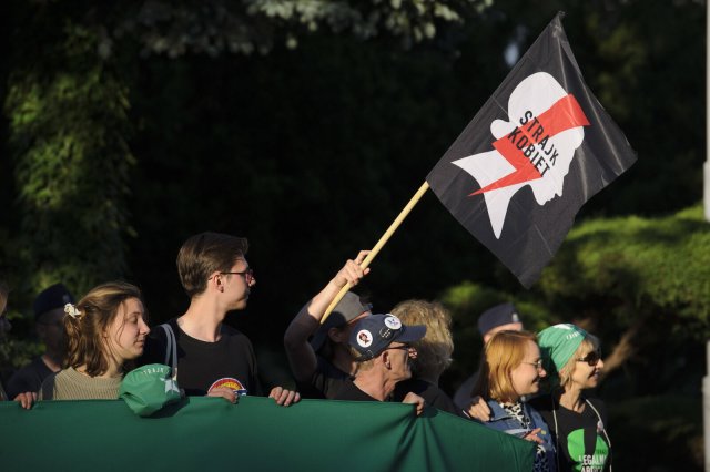 Demonstrant*innen halten eine Fahne mit dem Symbol der Protestbewegung Strajk Kobiet.