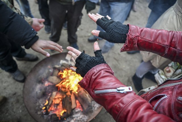 Obdachlose wärmen sich die Hände