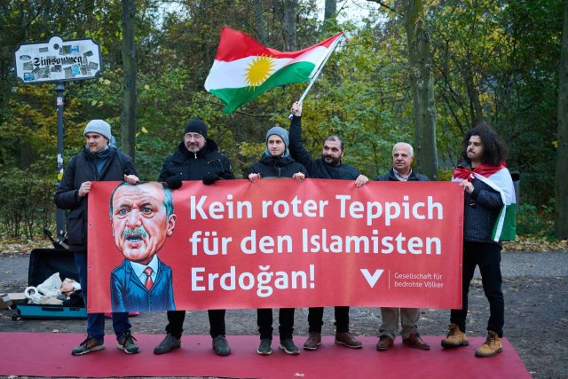 Bei einer Protestaktion der Gesellschaft für bedrohte Völker gegen den Besuch des türkischen Präsidenten Erdoğan halten Demonstranten ein Transparent.