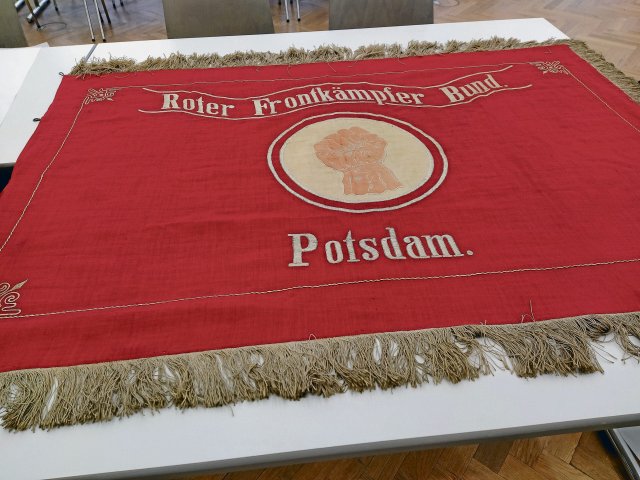 Die von Hand bestickte Fahne der Roten Frontkämpfer ausgebreitet auf einem Tisch im Potsdam-Museum