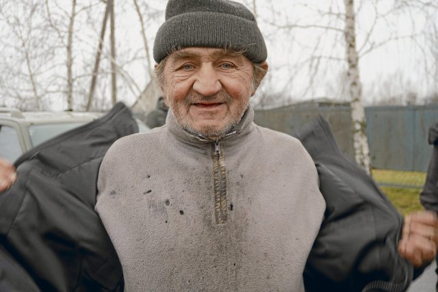 Ein Dorfbewohner in der Nähe von Lyman probiert eine neue Winterjacke an, die er von der Initiative Radical Aid Force bekommen hat.