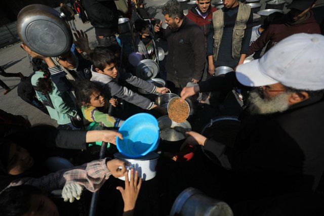 Palästinenser in der Stadt Rafah im südlichen Gazastreifen erhalten Essen. Die Weltgesundheitsorganisation WHO warnte vor einer unvorstellbaren Katastrophe, die die mögliche Ausweitung der israelischen Bodenangriffe in Rafah verursachen könnte.