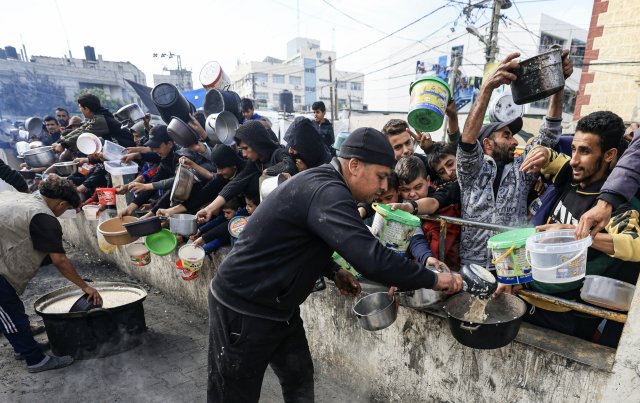 Palästinenser holen sich Essen an einer Spendenstelle in einem F...