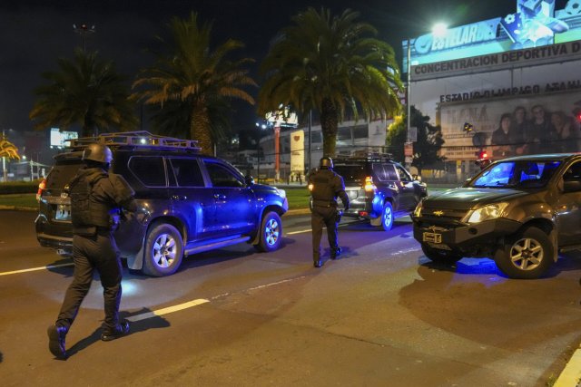 Polizisten bewachen Fahrzeuge, die in die mexikanische Botschaft in Quito, Ecuador, gefahren sind.