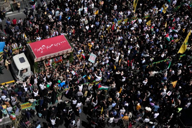 In Teheran versammeln sich Trauernde um einen Lastwagen, der die mit Fahnen bedeckten Särge von Mitgliedern der Revolutionsgarde (IRGC) trägt.