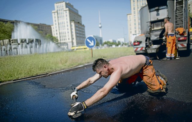 Straßenbauer, wie hier in Berlin, arbeiten nicht nur im Freien, sondern auch noch mit heißem Material