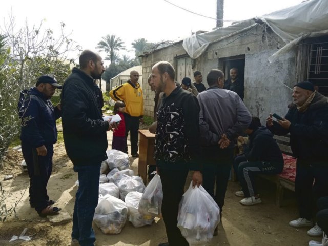 Freiwillige der Union of Agricultural Work Committees verteilen während des Krieges im Gazastreifen Lebensmittelpakete an bedürftige Haushalte.
