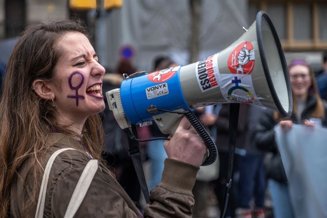 Eine Frau spricht über ein Megafon während einer Kundgebung anlässlich des Internationalen Frauentags.