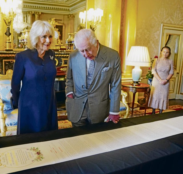 Camilla und Charles bestaunen die Endlos-Rolle, auf der die Zeremonie ihrer Inthronisation am 6. Mai 2023 protokolliert ist.