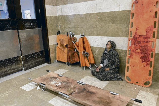 Eine palästinensische Frau, die bei einem israelischen Angriff auf ein Lager für Vertriebene in der Nähe von Khan Junis verletzt wurde, sitzt im Nasser-Krankenhaus im südlichen Gazastreifen auf dem Boden.