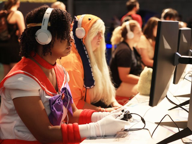 Auf der Spielemesse Gamescom testen Cosplayerinnen ein Computers...