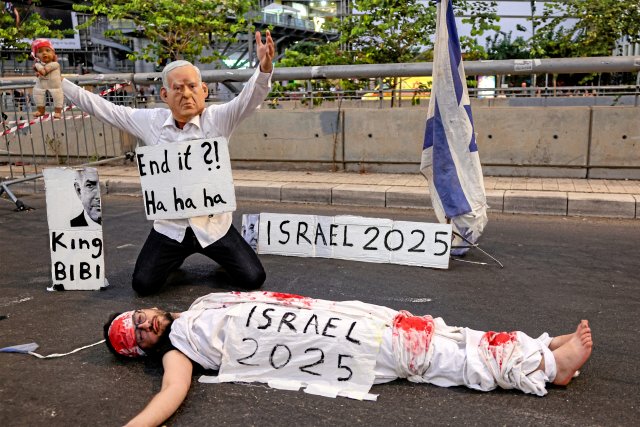 Ein Demonstrant mit einer Maske, die den israelischen Premiermin...
