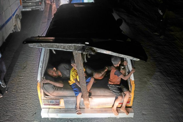 Ein Mann und zwei Kinder sind im Heck eines Autos zu sehen, als sie aus dem nördlichen Gazastreifen auf der Küstenstraße in Richtung Süden fliehen.