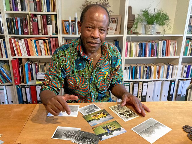 Ibraimo Alberto mit Fotos seiner Fußballmannschaften in der DDR