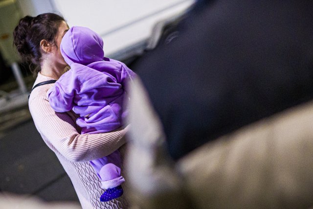 Eine Mutter aus Afghanistan, die mit ihrem Kind in einem Flugzeu...