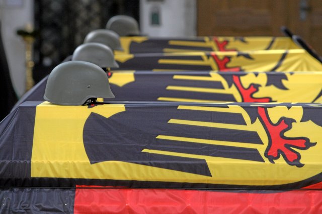 Vier S&auml;rge stehen am Samstag (24.04.2010) im M&uuml;nster von Ingolstadt (Oberbayern). Bundeswehr, Politiker, Familie und Freunde verabschiedeten sich bei einer Zentralen Trauerfeier von den vier am 15. April in Afghanistan get&ouml;teten Soldaten.... "Von allen diesen Gaben &ndash; Den Helm soll Michel nie mehr haben!"