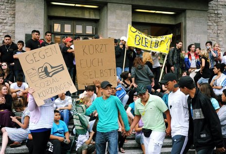 Nach dem versuchten Sturm auf das Rathaus tanzten Jugendliche friedlich gegen Kürzungen und zeigten ihre Sorge auf Schildern (unten).