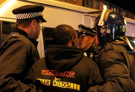 Polizisten nehmen in London einen mutmaßlichen Randalierer fest.