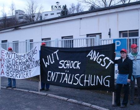 Mitarbeiter von Enka mit Protestplakaten vor dem Werkstor.