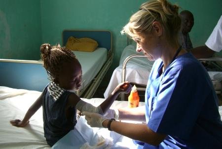 Kristin Menzel mit einer kleinen Patientin in Talinding und Kinder auf der Straße von Serekunda (unten)