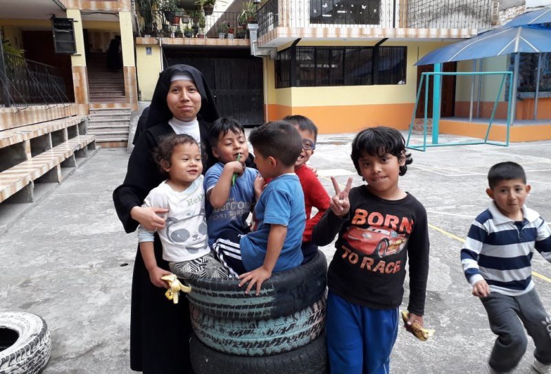 Eine Nonne des Oblata-Ordenes im Innenhof der »Casa de Acogida Buen Samaritano« in Quito mit Kindern von Migranten aus Venezuela