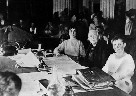 Clara Zetkin (am Tisch, Mitte) mit Alexandra Kollontai (links) auf der Zweiten Internationlaen Frauenkonferenz