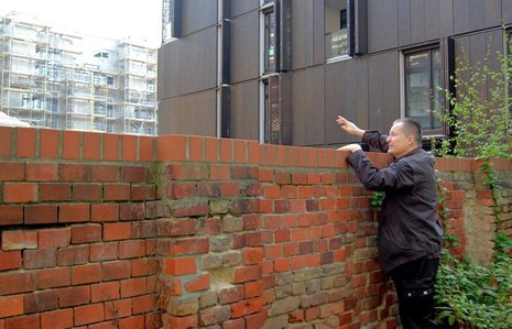 Hinter der Mauer: J&#246;rg Schleicher von der Anwohnerinitiative blickt auf die neuen Townhouses